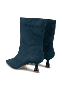 Botas de tobillo de ante azul con punta afilada y un distintivo tacón kitten que presenta un acento metálico en la base del tacón.
