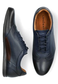 Niebieskie skórzane buty z perforowanym wzorem, okrągłym noskiem i brązowym akcentem po boku. Czarna gumowa podeszwa z sznurówkami.