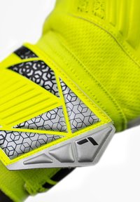 Neon-gelber Handschuh mit strukturiertem synthetischem Material, geometrischen schwarzen und silbernen Akzenten sowie gepolsterten Bereichen für besseren Griff und Schutz.