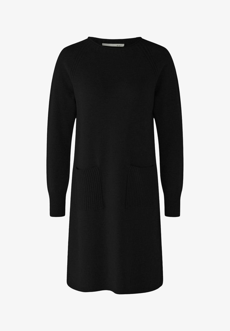 Robe tricotée noire avec un col rond, des manches longues et deux poches plaquées à côtes à l'avant. Texture lisse, coupe décontractée.
