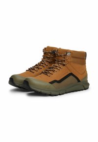 Scarpe da hiking marroni e verde oliva con tomaia in suede e mesh, occhielli in metallo e una suola in gomma spessa e texture. Presentano lacci multicolori.