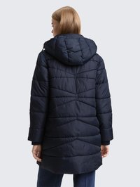 Námořnická prošívaná bunda s kapucí, prošívaným vzorem a dlouhými rukávy. Má mírně prodloužený zadní lem a hladkou strukturu.