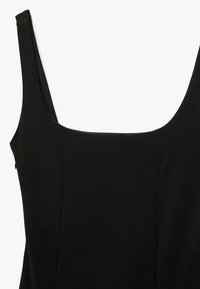 Schwarzes ärmelloses Kleid mit quadratischem Ausschnitt aus glattem Stoff, gezeigt vom oberen Torso, um seine Form und Textur hervorzuheben.