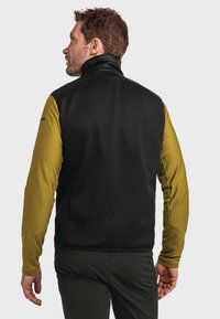 Schwarze und olivgrüne Weste mit hohem Kragen, strukturierten Ärmeln und taillierter Passform. Flexible Stoffe für Outdoor-Aktivitäten.