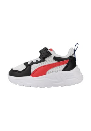 Scarpe da ginnastica per bambini con tomaia in rete bianca, dettagli in pelle nera, logo rosso e una cinghia in velcro. Presentano una suola bianca testurizzata.