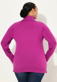 Maglione girocollo aderente viola con maniche lunghe, caratterizzato da una texture morbida e dettagli a coste sui polsini e sull'orlo.