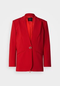 Blazer rouge sur mesure en tissu texturé ; doté d'un col cranté, d'une fermeture à un bouton et de poches latérales pour plus de détails.