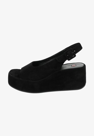 Sandalias de cuña de gamuza negra con punta abierta, correa tipo slingback con hebilla y una suela de plataforma gruesa para mayor altura.