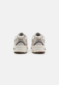 Witte mesh sneakers met textuurpanelen, subtiele blauwe accenten en een gevoerde zool. Voorzien van een gemusterde achterkant van de hak voor extra detail.