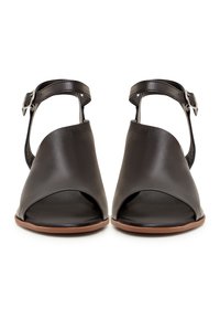 Czarne skórzane sandały na obcasie z otwartym palcem i wyciętym wzorem. Posiadają pasek wokół kostki z regulowanym zapięciem oraz beżową podeszwę. Gładka faktura.