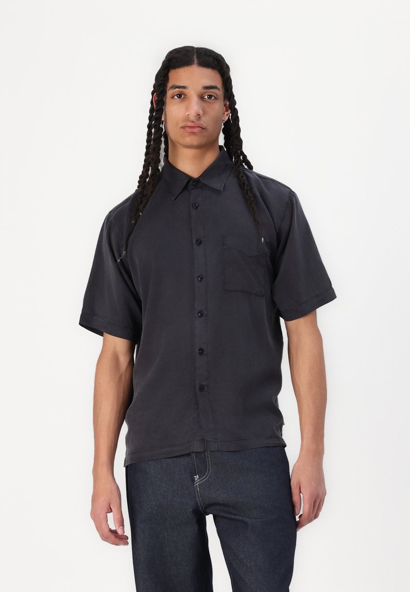 Schwarzes kurzärmliges Hemd mit Knöpfen aus leichtem Baumwollstoff, mit einer Brusttasche, klassischem Kragen und entspannter Passform.