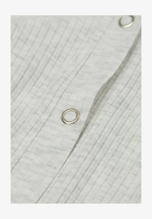 Tissu blanc texturé avec des rayures verticales, présentant un bouton en métal et une boutonnière. Vue en gros plan mettant en évidence les détails du tissu.