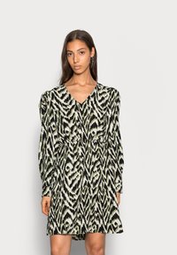 Vestido de manga curta em preto, creme e padrão animal verde, com decote em V, cintura ajustada e mangas bufantes franzidas.