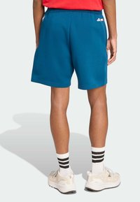 Blauwe sportshorts met een elastieken tailleband, zijzakken en een gladde textuur. Bevat het Adidas-logo op de achterkant van de tailleband.