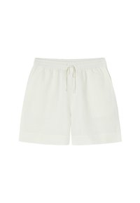 Cream-colored linen shorts with an elastic waistband and drawstring, featuring a loose fit and rolled hems. Simple design, lightweight texture.