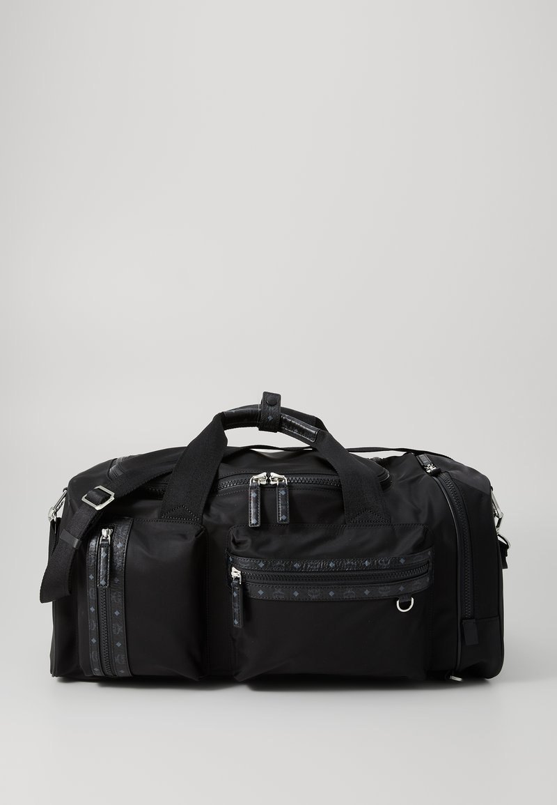 Black nylon duffle bag with multiple zippered pockets, textured straps, and silver hardware. Features a spacious main compartment and contrasting accents.
