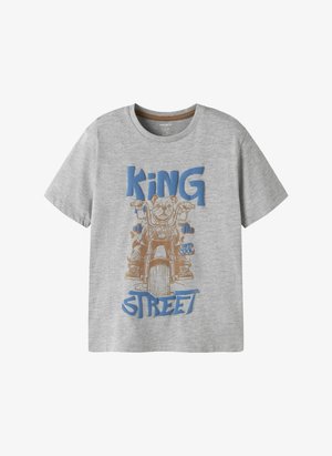 Hall lastetööriga T-särk kujutisega koerast, kes sõidab mootorrattal, ning sinise ja kuldse tekstiga "Tänava Kuningas, Väga Lahe".