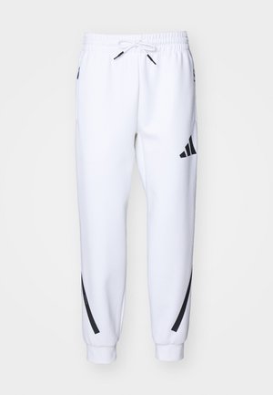 Biele športové nohavice s čiernymi detailmi, vyrobené z jemnej látky, s elastickým pásom, sťahovaním na šnúrku a bočnými vreckami.