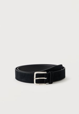 Ceinture en daim noire avec une boucle rectangulaire argentée, roulée sur un fond clair.