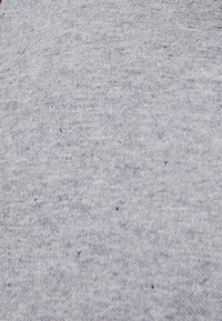 Jasnoszary materiał o miękkiej fakturze, z delikatnym melanżowym wzorem i małymi ciemnymi plamkami w całej powierzchni. Odpowiedni do codziennej odzieży.