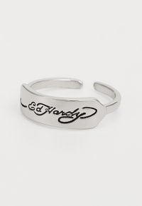 Sølv åpen ring med et flatt rektangulært ansikt gravert med "Ed Hardy" i kursiv skrifttype, glatt overflate med en lett glans.