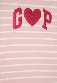 Pink striped t-shirt with white stripes, featuring glittery red letters "G," a heart, and "P" in bold, blocky design. Soft cotton texture.