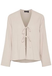 Light beige blouse with a deep V-neck, long sleeves, and front tie closure. Made from textured, soft fabric with a relaxed fit.