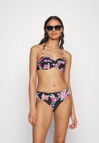 Gėlių bikini rinkinys, turintis juodą foną su rožinėmis gėlėmis, struktūrizuota viršutinė dalis su dirželiais ir derančios žemos liemenėlės kelnaitės.