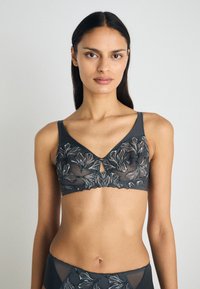Gray embroidered bralette featuring floral patterns, keyhole detail at the center, and wide straps. Sheer, textured fabric creates subtle contrast.