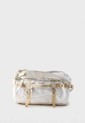 Borsa duffel bianca e beige con tasca frontale con cerniera, doppie fibbie e tracolla regolabile su sfondo semplice.