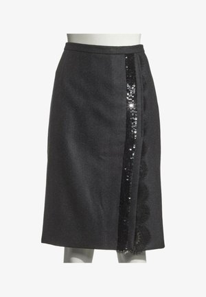Jupe noire longueur genou avec un panneau latéral orné de sequins noirs verticaux et de détails en dentelle.