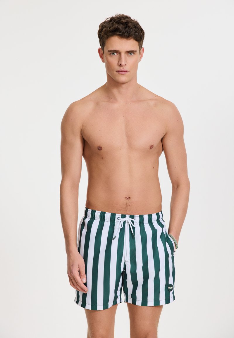 Herren Badeshorts in grün-weißen vertikalen Streifen, ausgestattet mit einem elastischen Bund mit Kordelzug und Seitentaschen. Glattes Polyestergewebe.