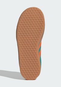 Shoe sole with a patterned rubber texture, featuring orange and teal stripes on the side. Solid brown outsole with a textured grip.