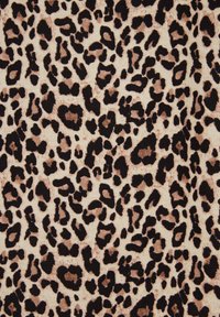 Leoparda raksta audums ar spilgti melniem un tumši brūniem plankumiem uz krēma fona, ar mīkstu tekstūru un dažādām plankumu izmēriem.