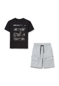 Camiseta de algodón negra con bocetos en blanco de vehículos de Batman. Pantalones cortos gris claro con cintura elástica y dos bolsillos laterales cargo, acentuados con el símbolo de Batman.