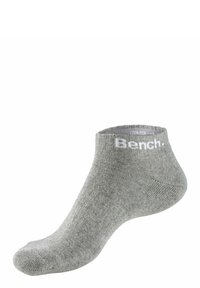Grey ankle sock made of cotton blend material with ribbed texture. Features white "Bench." logo at the cuff and a smooth toe seam.