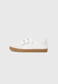White sneaker with velcro straps, perforated design on the sides, light grey accents, and a tan rubber sole. Rounded toe shape.