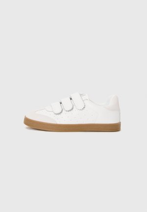 Zapatilla blanca con correas de velcro, diseño perforado en los laterales, acentos en gris claro y suela de goma color marrón. Punta redondeada.