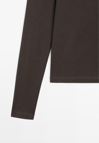 Langsleeve bruin t-shirt van een zacht, rekbaar materiaal met een slim fit ontwerp; heeft een rechte onderrand en eenvoudige stikdetails.