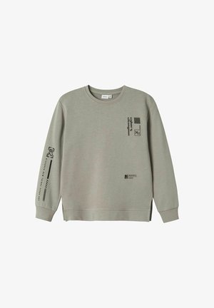 Sweat-shirt gris clair à manches longues avec poignets côtelés, petits motifs géométriques noirs et textes sur la poitrine et la manche droite.