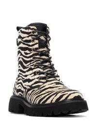Botas de tobillo con cordones que presentan un patrón de cebra en tonos marrón y negro, fabricadas con un material texturizado, suela negra gruesa y detalles en dorado.