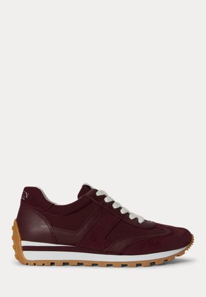 Zapatilla deportiva burdeos con cordones blancos, suela de goma marrón y raya blanca encima de la suela en vista lateral.