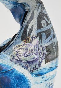 Blue and black textile featuring floral patterns, textured stitching, and abstract designs, with visible seams and a smooth finish.