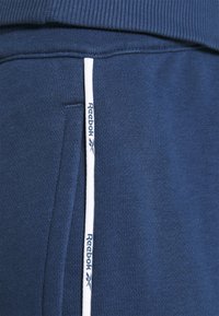 Reebok PIPING JOGGER - Calças de fato de treino - batik blue