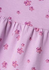 Tessuto lilla con piccole stampe di fiori rosa. Il design presenta volants arricciati nella parte inferiore per texture e dettagli.