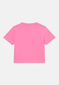 T-shirt en coton rose à manches courtes avec un col rond, présentant une texture lisse et des coutures soignées le long de l'ourlet et des manches.