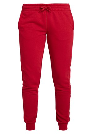 Red sweatpants made of cotton with an elastic waistband, adjustable drawstring, and ribbed cuffs. Features two side pockets.