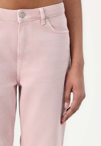 Jeans in denim rosa chiaro con vita alta, caratterizzati da una chiusura frontale con bottone, tasche laterali e una trama liscia.
