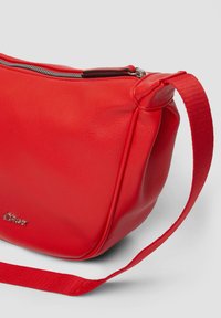 Czerwona skórzana torebka na ramię z fakturowanym wykończeniem, zamykana na zamek błyskawiczny, z płaskim materiałowym paskiem. Mały detal logo z przodu.