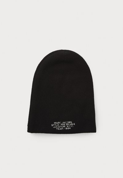 Black knit beanie made of ribbed fabric, featuring white embroidered text at the front displaying brand name and style details.